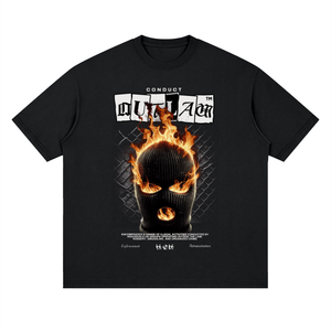 A black short-sleeve t-shirt with a graphic print on the front. The graphic features the text 'CONDUIT OUTLAVER' above a black balaclava mask engulfed in orange and yellow flames, set against a dark chain-link fence background.