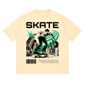 A cream-colored short-sleeve t-shirt with a graphic print of a skateboarder in black and green, featuring the word 'SKATE' in bold black letters above the illustration.
