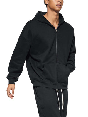 Person wearing a black zip-up hoodie and pants on a white background