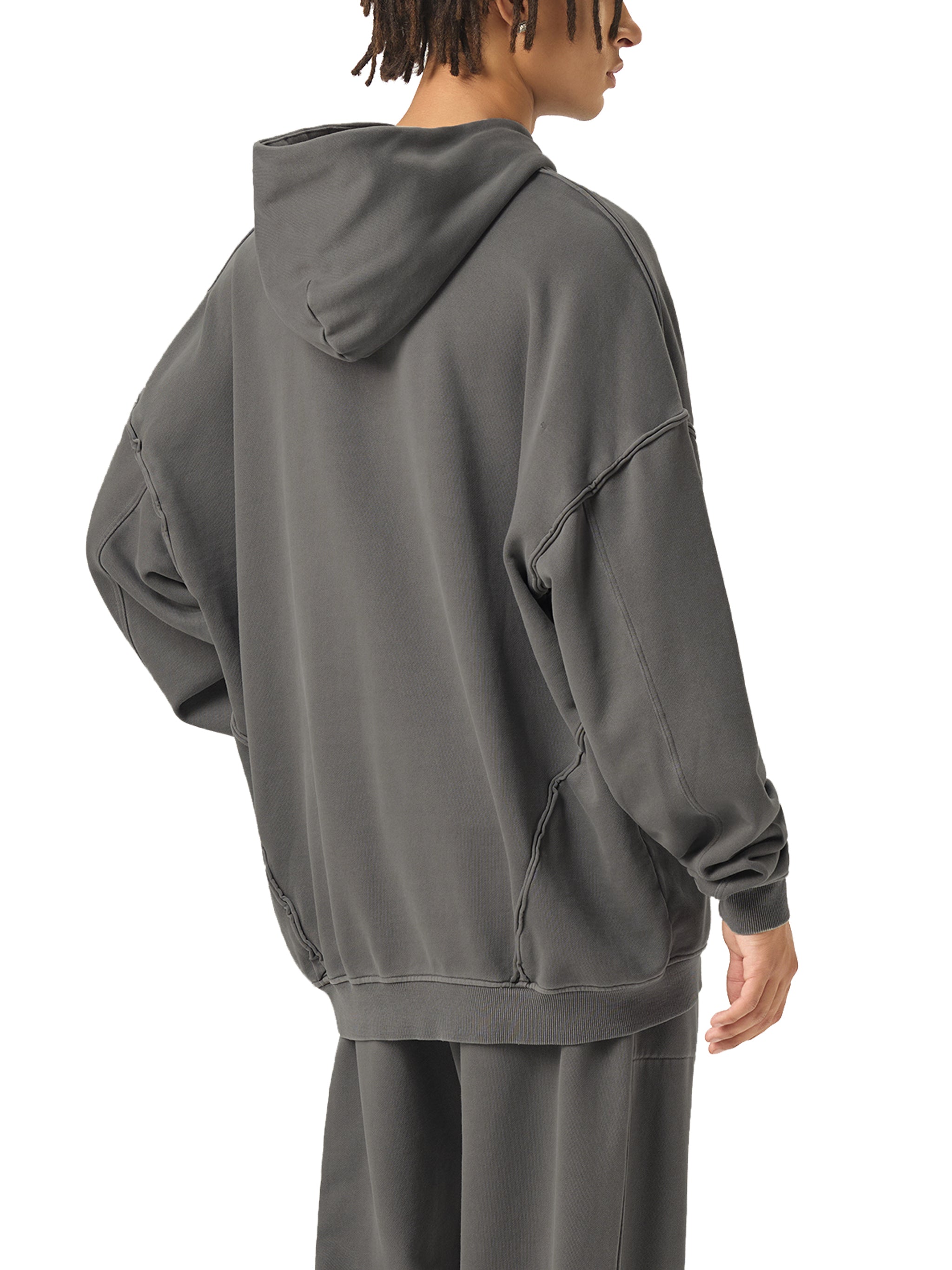 Person wearing a gray hoodie and pants on a white background