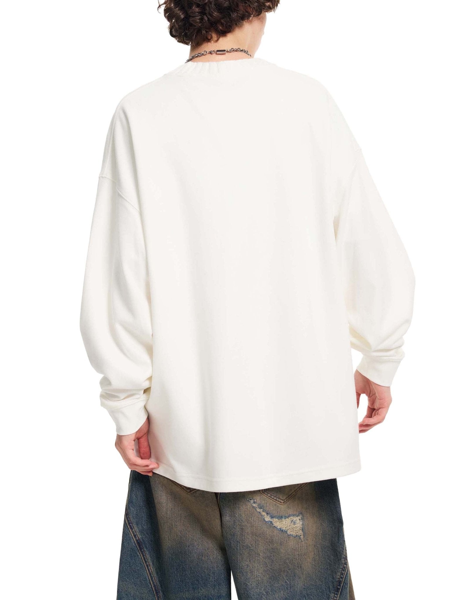 Person wearing a white long-sleeve shirt and blue jeans on a white background