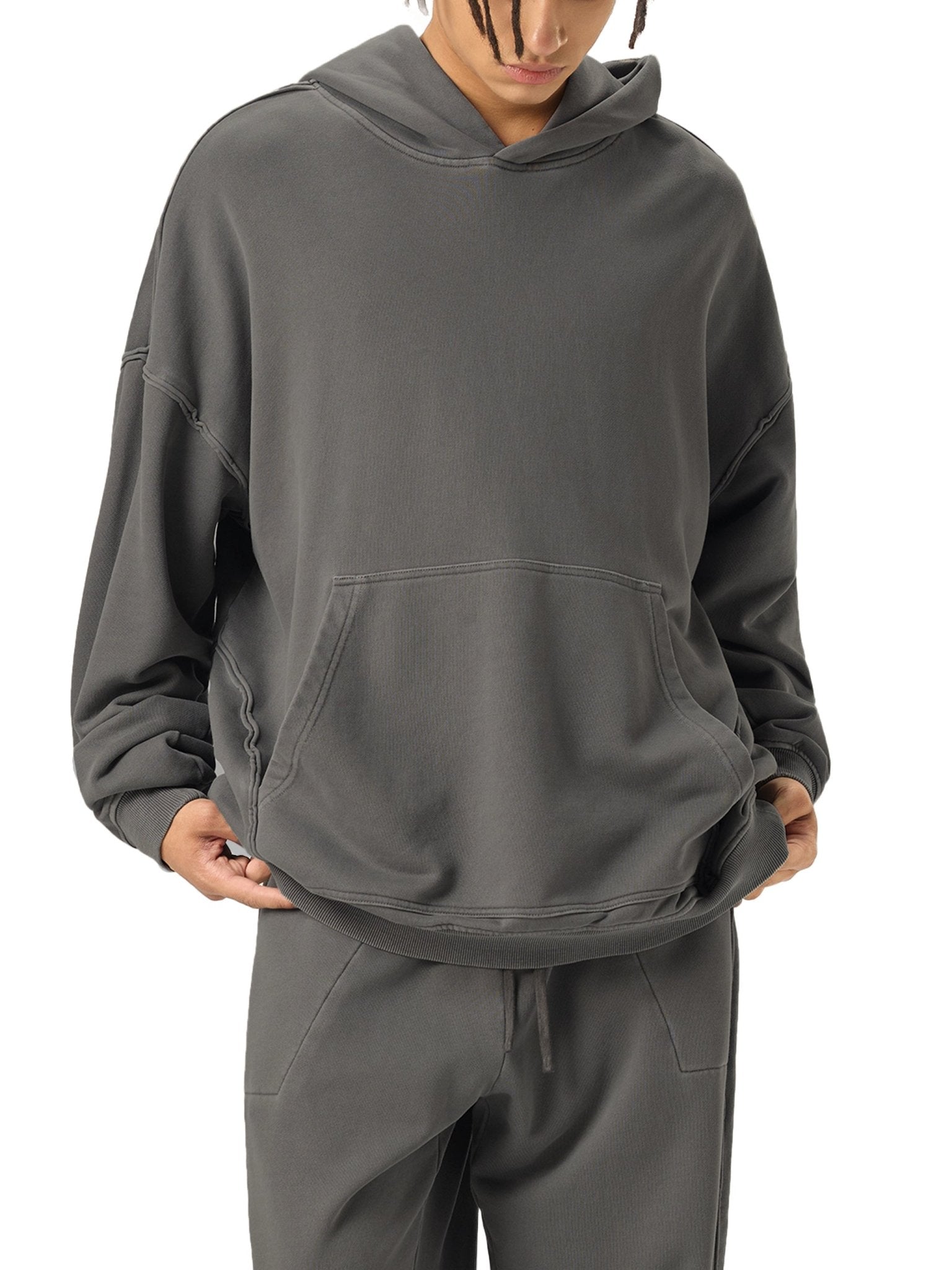 Person wearing a gray hoodie and pants on a white background