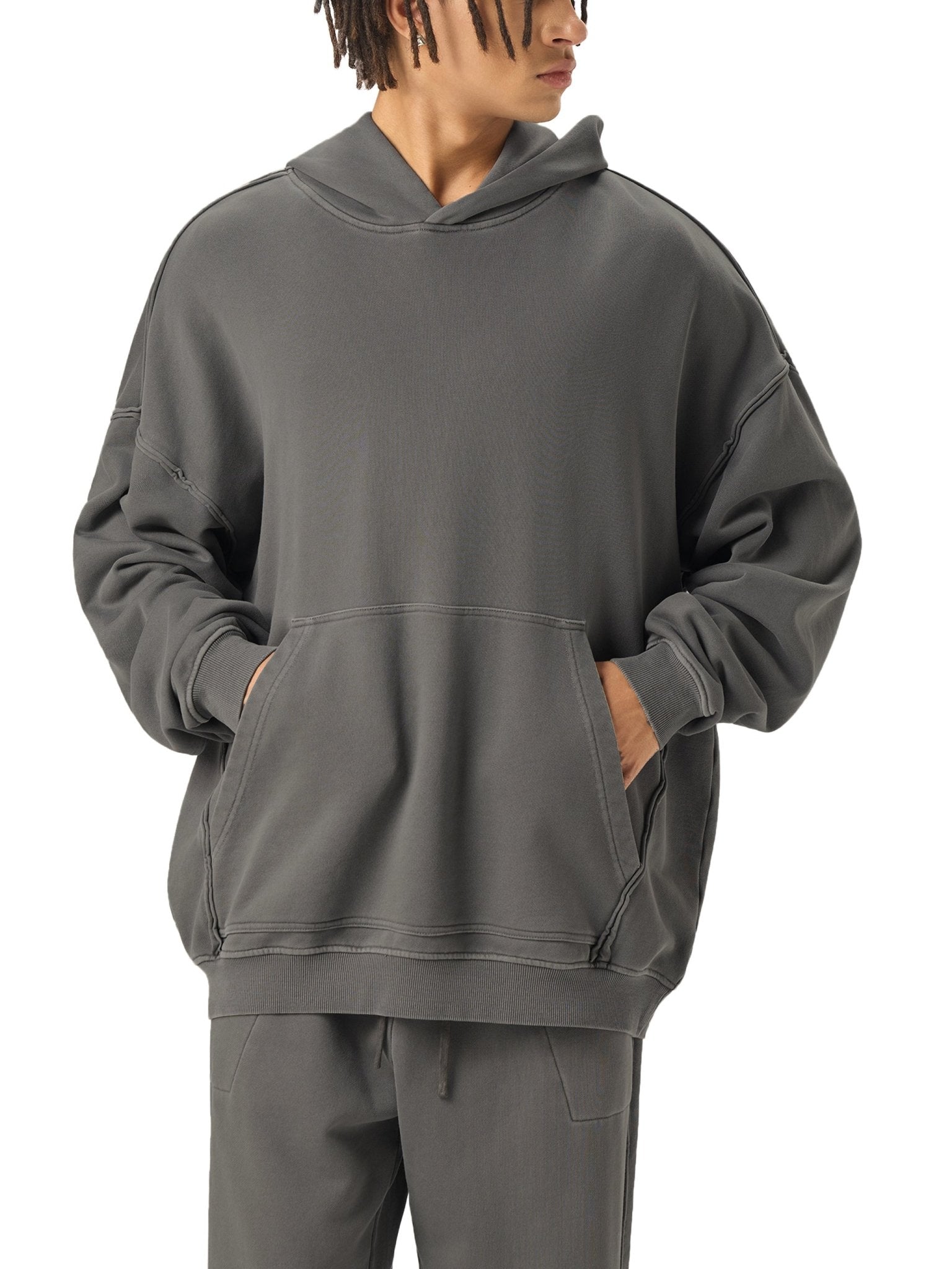 Person wearing a gray hoodie and pants on a white background