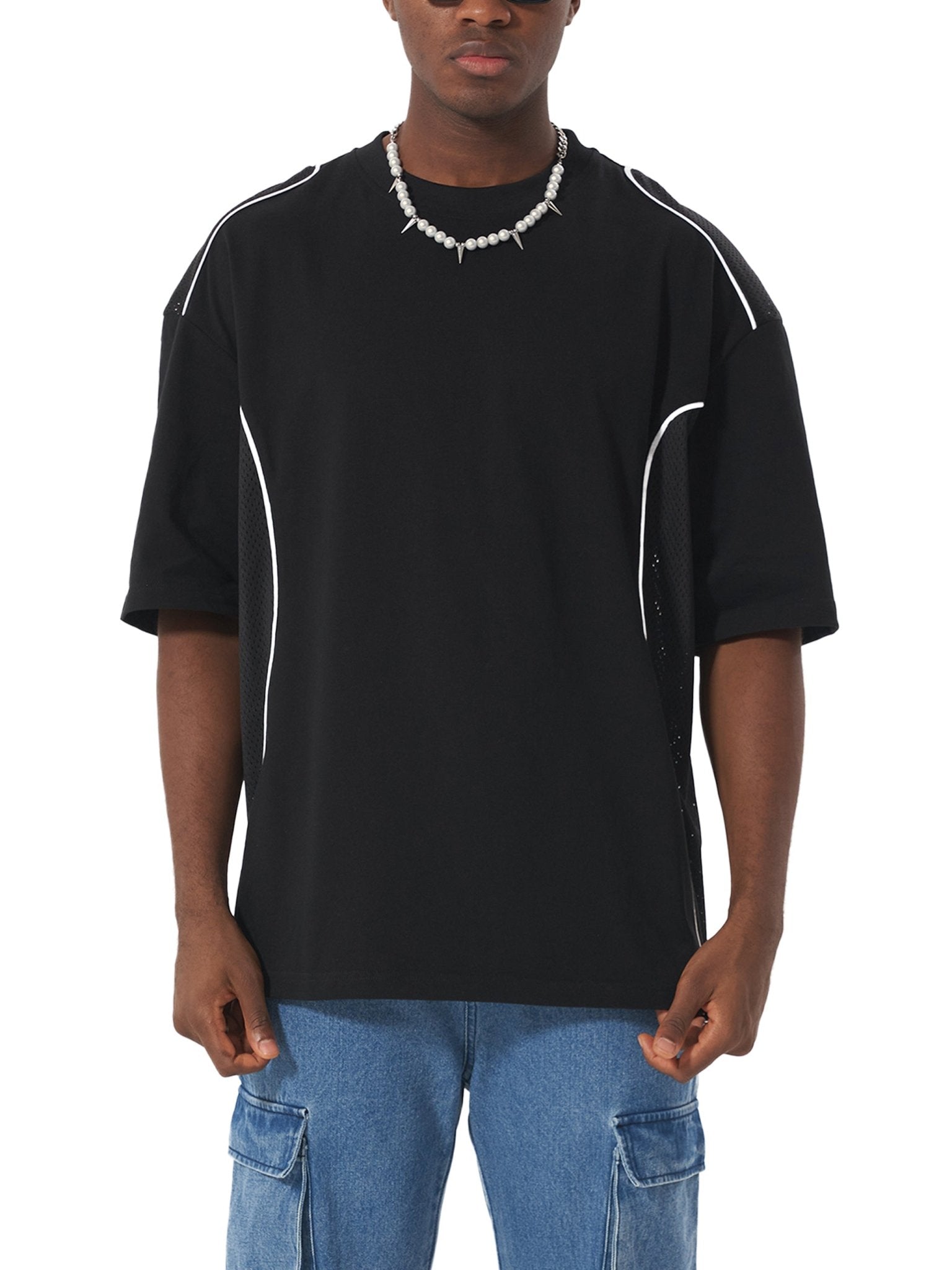 Person wearing a black t-shirt with white accents on a white background