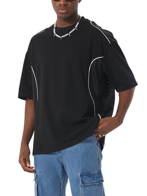 Person wearing a black t-shirt with white accents and blue jeans on a white background