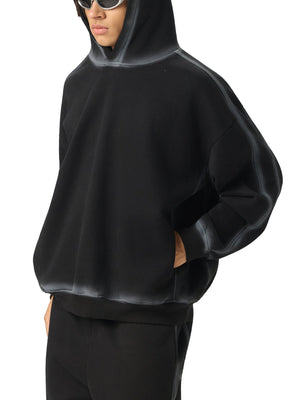 Person wearing a black hoodie and pants on a white background