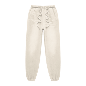 Beige sweatpants with ruffled details on a white background