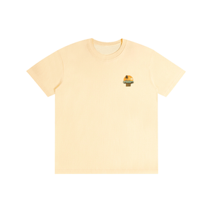 A pale yellow short-sleeve crewneck t-shirt with a small graphic print on the left chest, displayed flat against a solid white background.