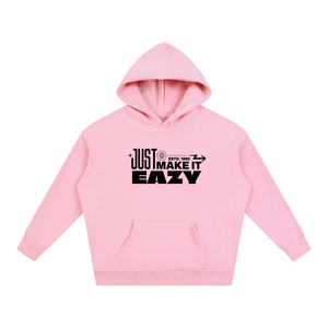 A light pink pullover hoodie with a black graphic text print on the chest reading 'JUST MAKE IT EASY' and a small circular logo, displayed on a solid white background.