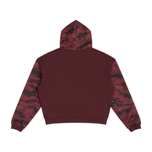 A cropped hoodie shown from the back, featuring a solid deep burgundy body with contrasting red and black camouflage sleeves and hood.