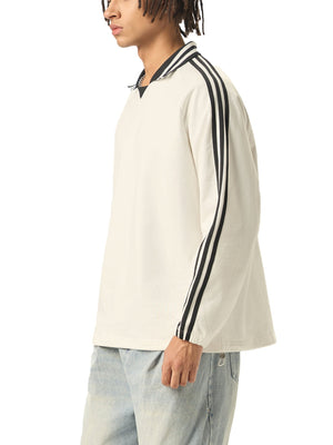 Person wearing a white long-sleeve shirt with black stripes on a white background