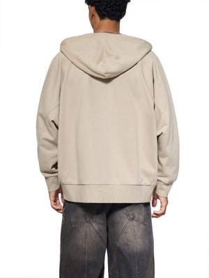 Person wearing a beige hoodie from behind on a white background