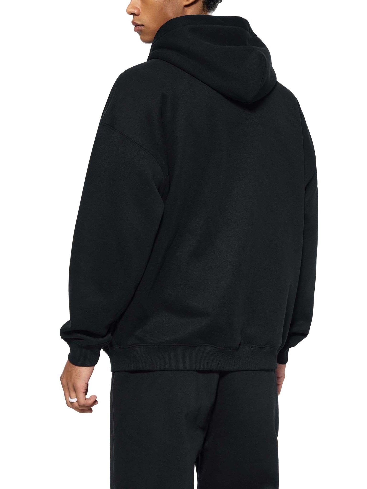 Person wearing a black hoodie from behind on a white background