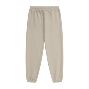 A pair of light beige jogger pants with an elastic waistband and ribbed ankle cuffs, shown flat against a solid white background.