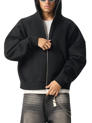 Person wearing a black hoodie with a white shirt and gray jeans on a white background