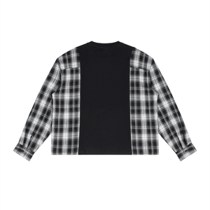 A long-sleeve cropped shirt with a black center panel and black-and-white plaid sleeves, shown flat against a white background.
