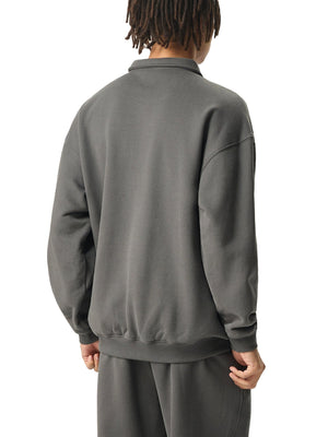 Person wearing a gray tracksuit on a white background