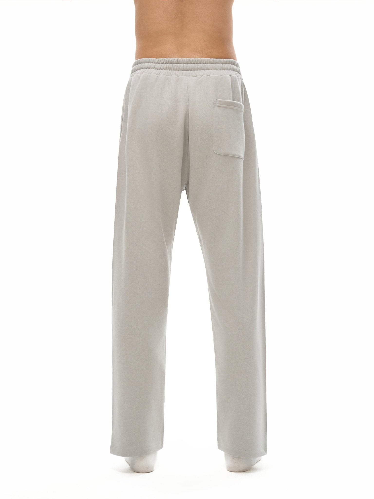 Light gray sweatpants worn by a person on a white background