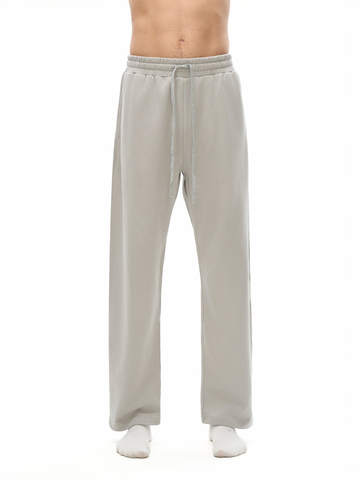 Light gray sweatpants worn by a person on a white background