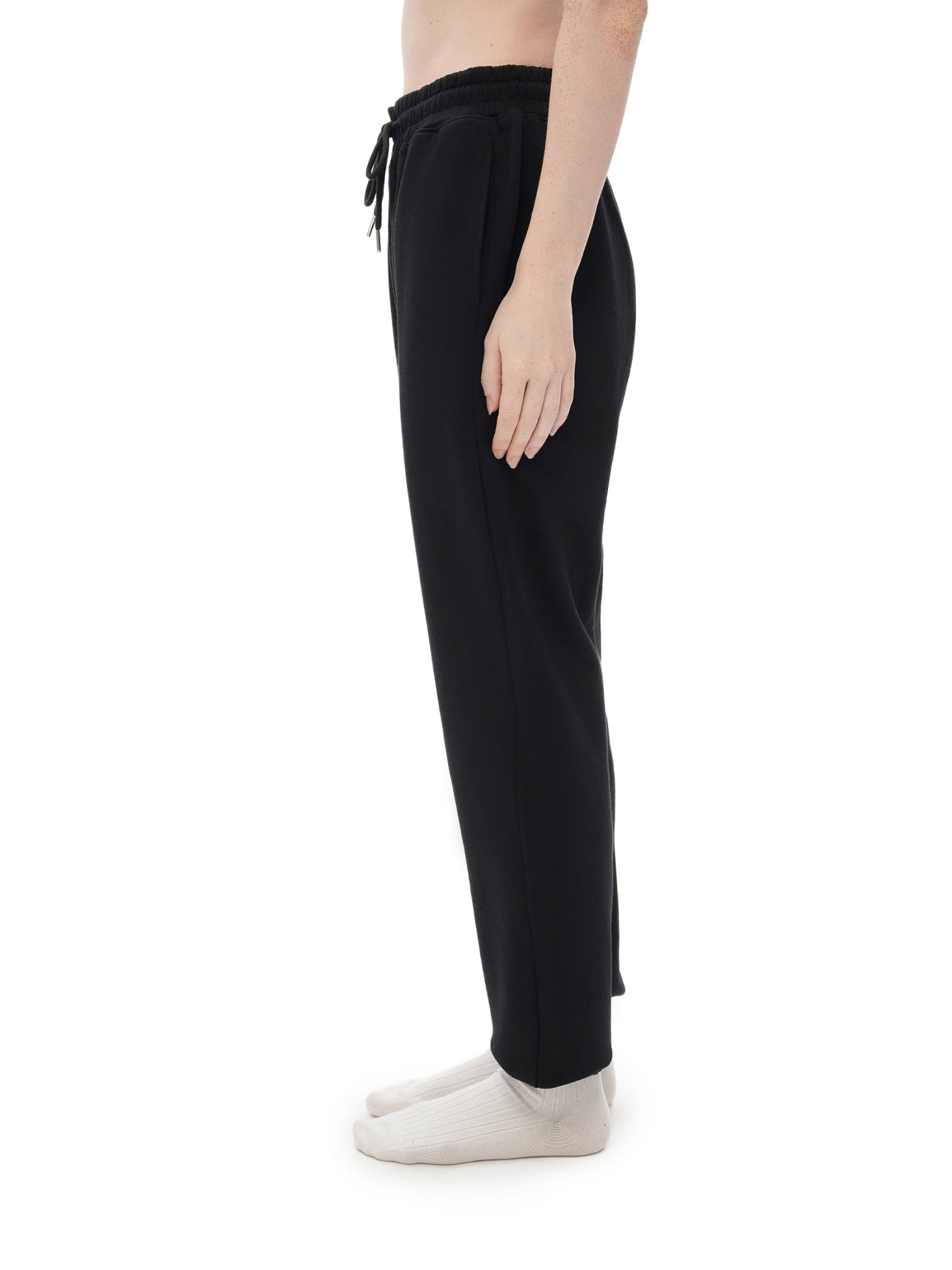 Black pants worn by a person on a white background