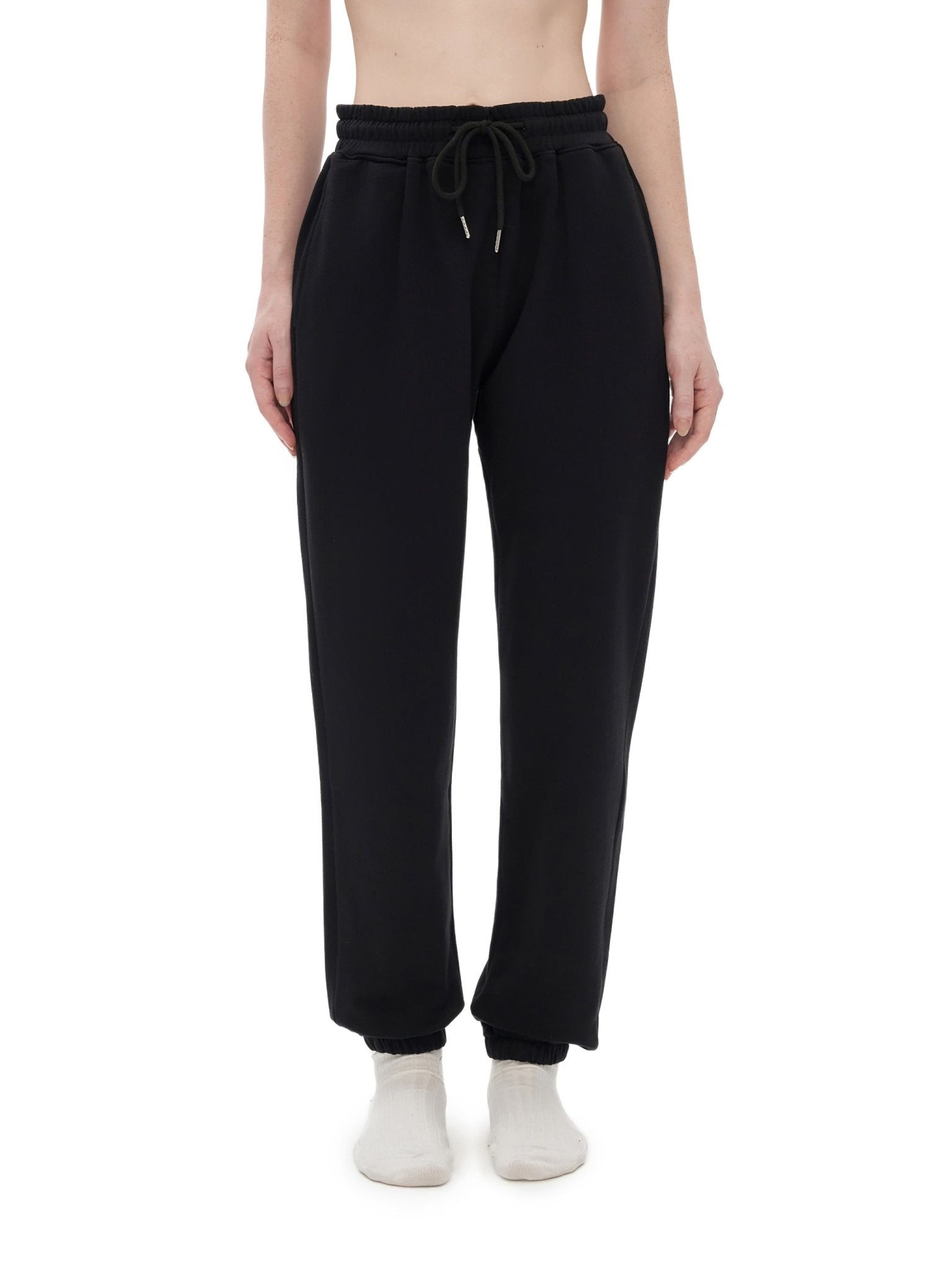 Black sweatpants worn by a person on a white background