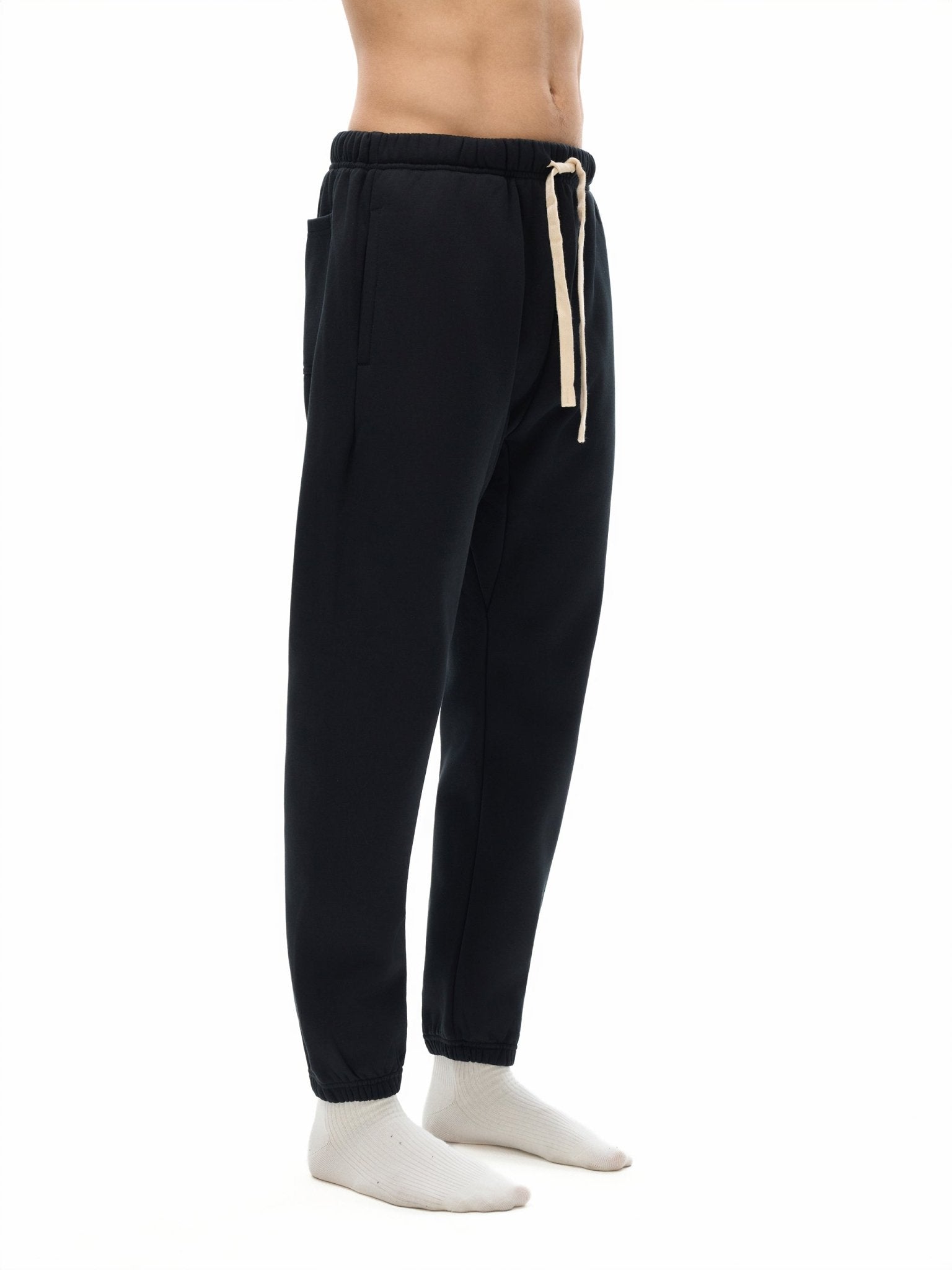 Black jogger pants with a drawstring on a white background