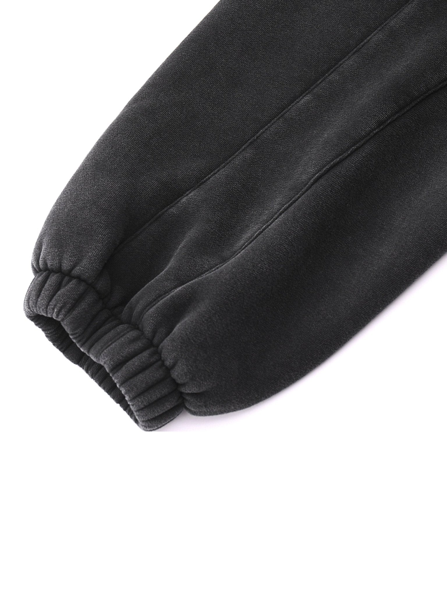 Close-up of dark gray sweatpants on a white background