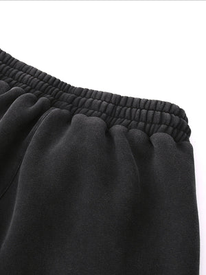 Close-up of black sweatpants with a white background