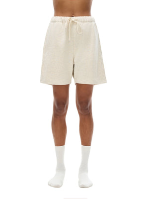 Beige shorts worn by a person on a white background