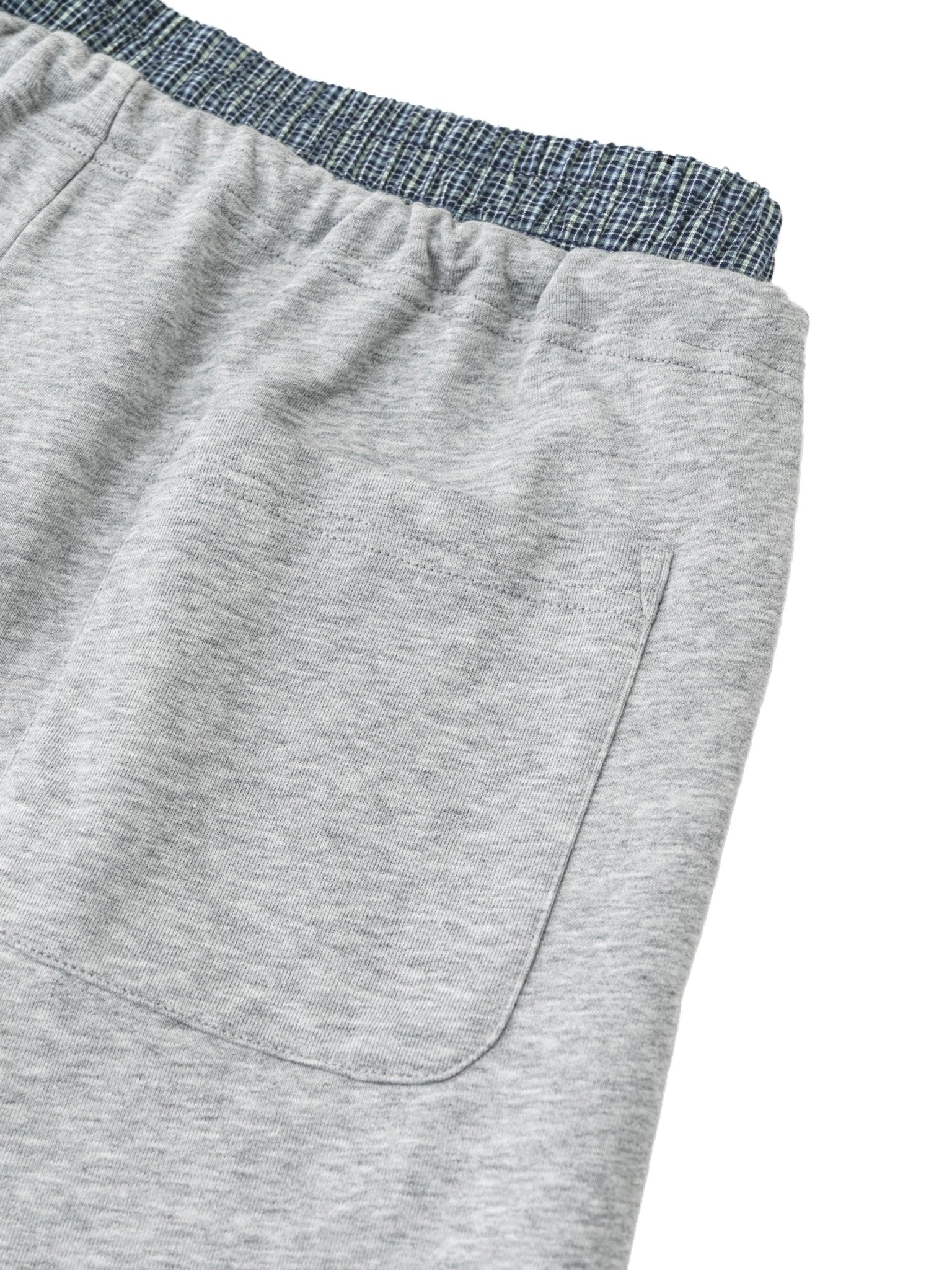 Close-up of gray shorts with a blue waistband on a white background