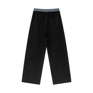 Black pants with a plaid waistband on a white background